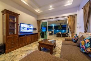 un soggiorno con divano e TV a schermo piatto di Private 3 Bedroom Pool Villa PP10 a Hua Hin