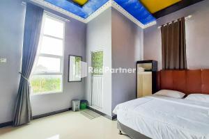 a bedroom with a bed and a blue ceiling at MT Syariah Homestay Kerinci RedPartner in Pondokpematangtanah