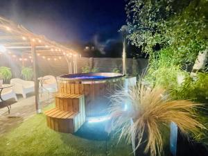 a hot tub in a garden at night at Domki i Apartamenty Całoroczne Koliber in Władysławowo