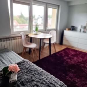Schlafzimmer mit einem Bett, einem Tisch und Stühlen in der Unterkunft Fredry 15F in Krakau