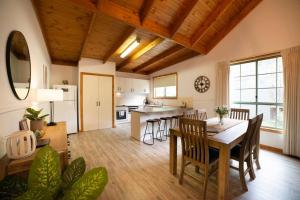 a kitchen and dining room with a table and chairs at Country Lane Cottage in Halls Gap