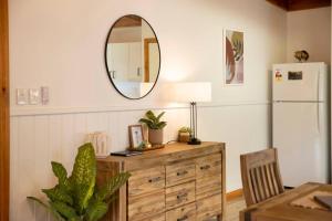 a dining room with a dresser and a mirror at Country Lane Cottage in Halls Gap