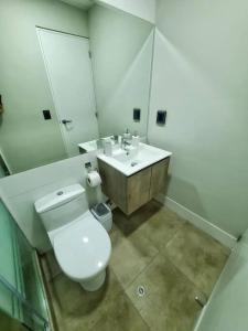 La salle de bains est pourvue de toilettes blanches et d'un lavabo. dans l'établissement Apartamento estreno céntrico y moderno, à Lima