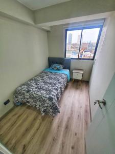 a small bedroom with a bed and a window at Apartamento estreno céntrico y moderno in Lima