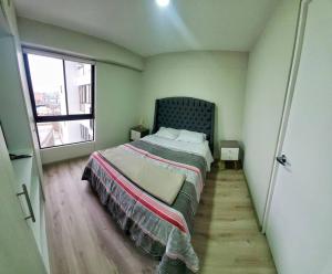 - une chambre avec un lit dans une pièce dotée d'une fenêtre dans l'établissement Apartamento estreno céntrico y moderno, à Lima