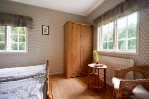 1 dormitorio con 1 cama, 1 mesa y 2 ventanas en Savolax Stugor, en Axland