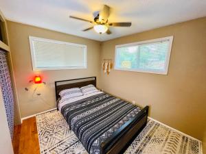 1 dormitorio con 1 cama y ventilador de techo en Welcome! Colorful 50's Ranch in the Heart of Eugene, en Eugene