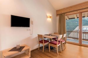 a dining room with a table and a balcony at Hohenegg Apartment Karolina in Campolasta