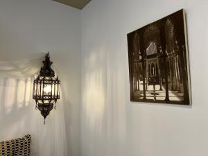 un lampadario pendente appeso a un muro con un quadro di Sueños de la Alhambra a Granada