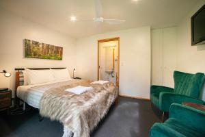 大廳峽的住宿－拉庫納度假屋，一间卧室配有一张床和一把绿色椅子
