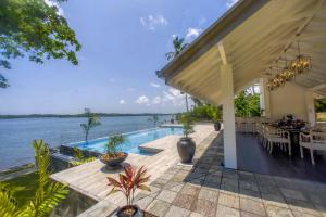 an outdoor dining area with a view of the water at The Niche by DBI in Hikkaduwa