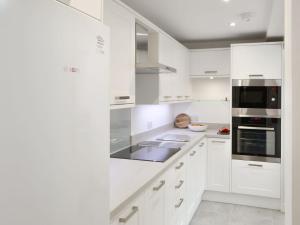 uma cozinha branca com armários e electrodomésticos brancos em Drovers em Morpeth