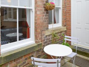 uma mesa branca e cadeiras em frente a uma janela em Drovers em Morpeth