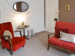 - un salon avec deux chaises rouges et une table dans l'établissement Drovers, à Morpeth