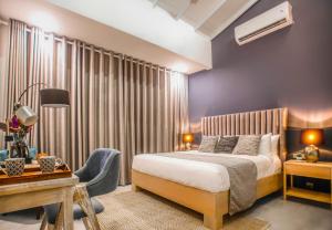 a bedroom with a bed and a desk and a chair at The Niche Hikkaduwa - 10 minutes to the beach in Hikkaduwa