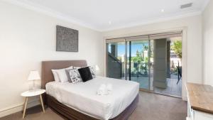 a bedroom with a bed and a balcony at Unit 18 - 3 Bed Part Ocean View in Terrigal