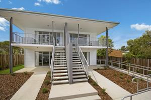 a house with a staircase in front of it at Cooroy Luxury Motel Apartments in Cooroy
