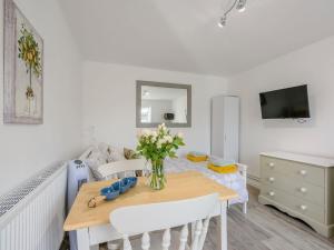 a dining room with a table with flowers on it at The Gardens in Santon