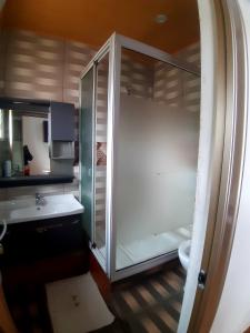 a bathroom with a glass shower and a sink at Human hotel Ivato in Antananarivo