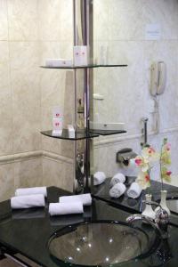 a bathroom with a sink and a mirror at Ramada by Wyndham Tashkent in Tashkent