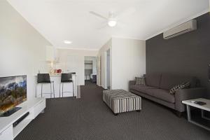 a living room with a couch and a kitchen at Cooroy Luxury Motel Apartments in Cooroy