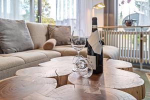 - une bouteille de vin sur une table en bois avec un verre dans l'établissement Fewo Luzia, à Schönwald