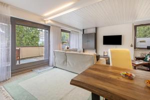 een woonkamer met een tafel en stoelen en een televisie bij Fewo Luzia in Schönwald