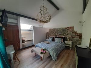 a bedroom with a bed and a brick wall at Gîte La Columbia Lens en Hainaut in Cambron-Saint-Vincent