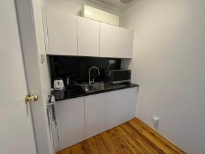a small kitchen with a sink and a microwave at Baths Motel Moree in Moree