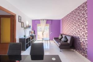 sala de estar con paredes de color púrpura y sofá en Rooms Salomons by easyBNB, en Alcalá de Henares