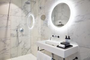 a white bathroom with a sink and a mirror at TORTUE Hamburg in Hamburg