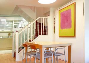 a dining room with a table and chairs and a staircase at Casa La Hiedra dúplex independiente jardín privado in Panticosa