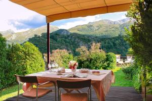 a table on a deck with a view of mountains at Casa La Hiedra dúplex independiente jardín privado in Panticosa