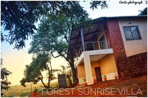 una casa en una colina con un árbol en Forest Sunrise Villa 3BHK, en Mahabaleshwar