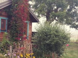 uma casa com flores a crescer ao lado dela em Domek na Skraju Wsi dostęp do jeziora UBLIK em Konopki Wielkie