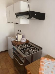 una cucina con piano cottura in acciaio inossidabile forno superiore di Casa di campagna Villa De Luca a Bellante