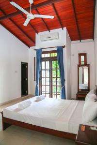 a bedroom with a large bed with a ceiling fan at Cinnamon Fence in Colombo