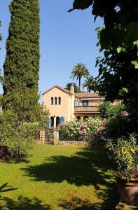 een groot huis met een palmboom in een tuin bij Super Manoir à Cannes YourHostHelper in Cannes