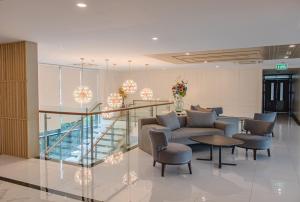 a lobby with a couch and chairs and a table at ONE Hotel in Pathum Thani