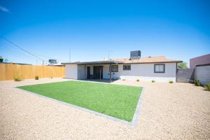 a house with a yard with a green lawn at Charming 2 Bedroom House in Las Vegas