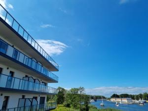 a building with a view of the water and boats at Apartament Porta Mare BASEN SAUNA SPA Latika Dziwnów in Dziwnów