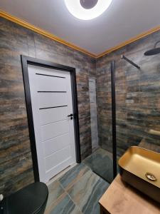 a bathroom with a white door and a sink at Apartament Porta Mare BASEN SAUNA SPA Latika Dziwnów in Dziwnów