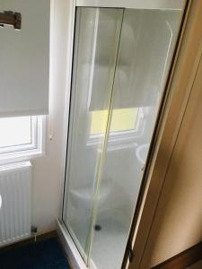 a glass shower in a room with a window at Jacobs Retreat- Lido Beach- well behaved dogs welcome in Prestatyn