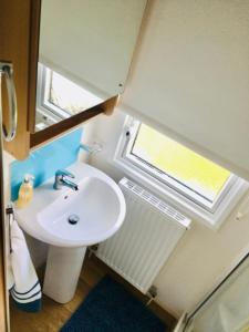 a bathroom with a sink and a window at Jacobs Retreat- Lido Beach- well behaved dogs welcome in Prestatyn