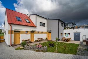una casa con techo rojo y patio en Penzion ENO en Kelčany