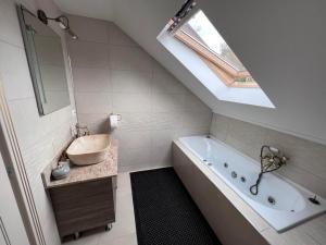 a bathroom with a sink and a tub and a window at Casa Helen Insurance&Tourism in Gălăuţaş
