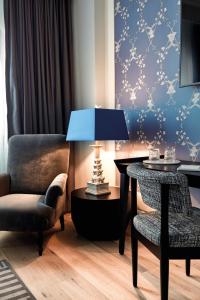 a living room with a table and a chair and a lamp at TORTUE Hamburg in Hamburg