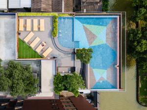 an overhead view of a swimming pool with a building at The Quart Ruamrudee by UHG in Bangkok