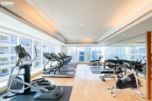 a gym with treadmills and elliptical machines at bnbmehomes - Live & Work 'w' Style in 1B Apt - 3007 in Dubai