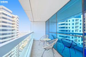 a balcony with chairs and a table on a building at bnbmehomes - Live & Work 'w' Style in 1B Apt - 3007 in Dubai